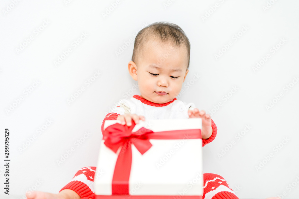 Little baby boy smile and excited in christmas gift box in Christmas celebration.2 years old boy child holding red gift box on white background. Little baby boy smile and excited in christmas gift box in Christmas celebration.2 years old boy child holding red gift box on white background.