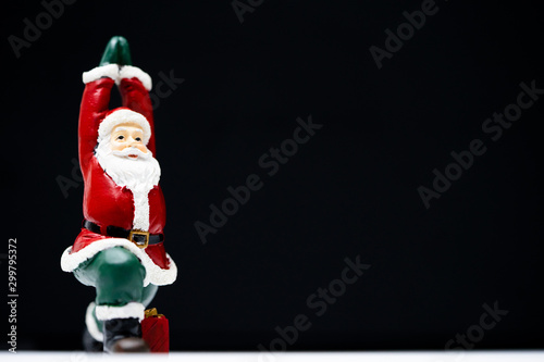 Santa Claus ready for give gift for Christmas eve and poses like a yoga practice be easily changed into overlay isolated on black background with copy space photo