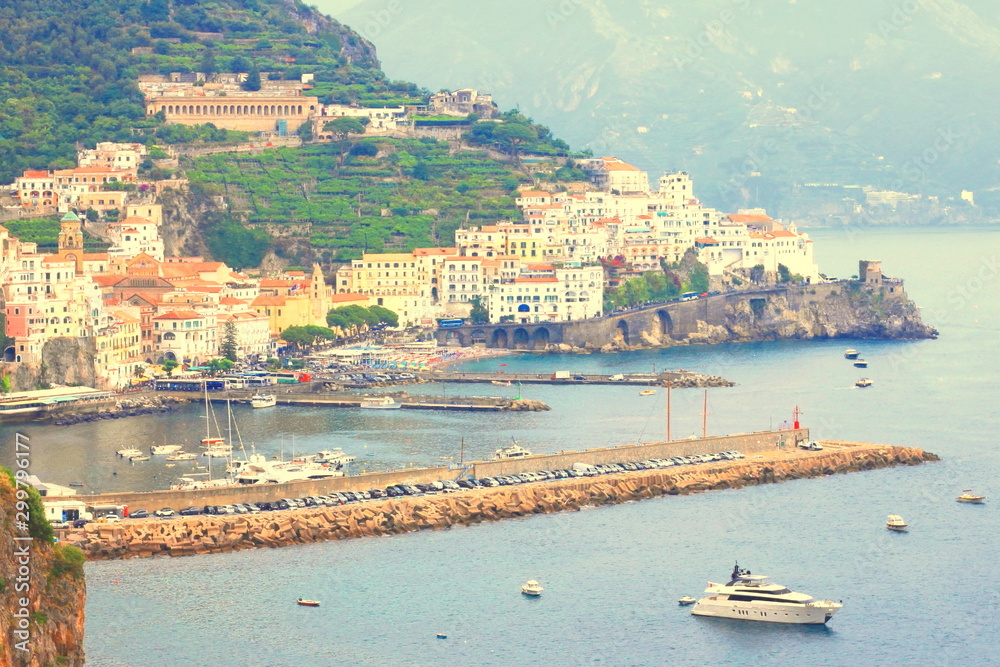 Panoramic scenic view of Amalfi Coast, Campania, Italy, in summer with traditional Italian architecture on mountains, beautiful blue sea and luxury yachts