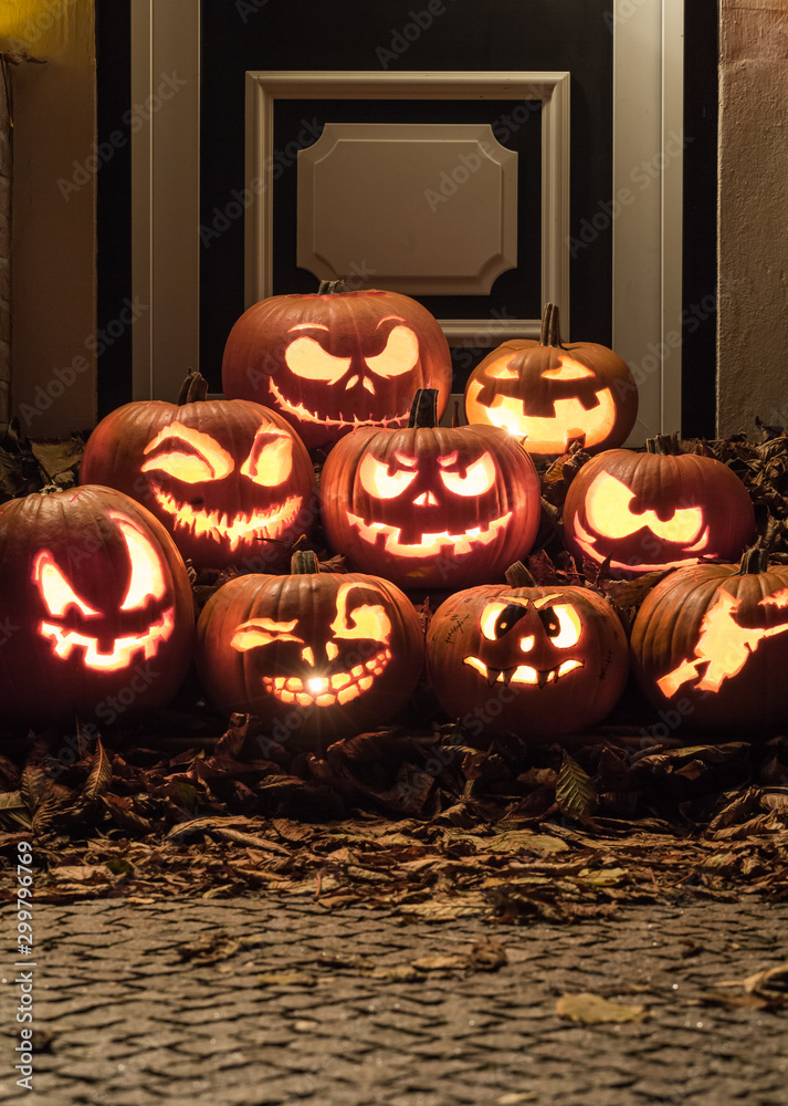 Fototapeta premium Night shot of illuminated pumpkins in front of a house