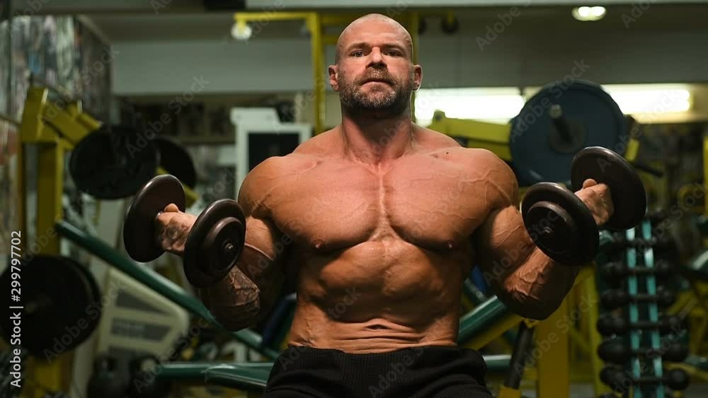 Handsome strong athletic man pumping up biceps muscles workout fitness and bodybuilding concept background - muscular bodybuilder fitness men doing arms exercises in gym naked torso Handsome strong athletic man pumping up biceps muscles workout fitness and bodybuilding concept background - muscular bodybuilder fitness men doing arms exercises in gym naked torso