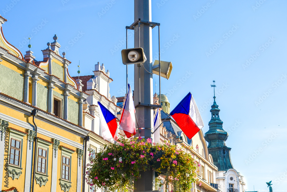 Small Czech flags waving on the street during the national holiday celebration. Historical buildings in the background. Czech Republic democracy and freedom concept. Bohemia, Moravia, and Silesia