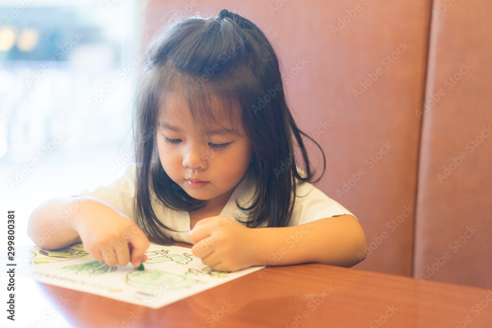 fine motor skills development concept.Little asian girl learning painting drawing in restaurant. fine motor skills development concept.Little asian girl learning painting drawing in restaurant.