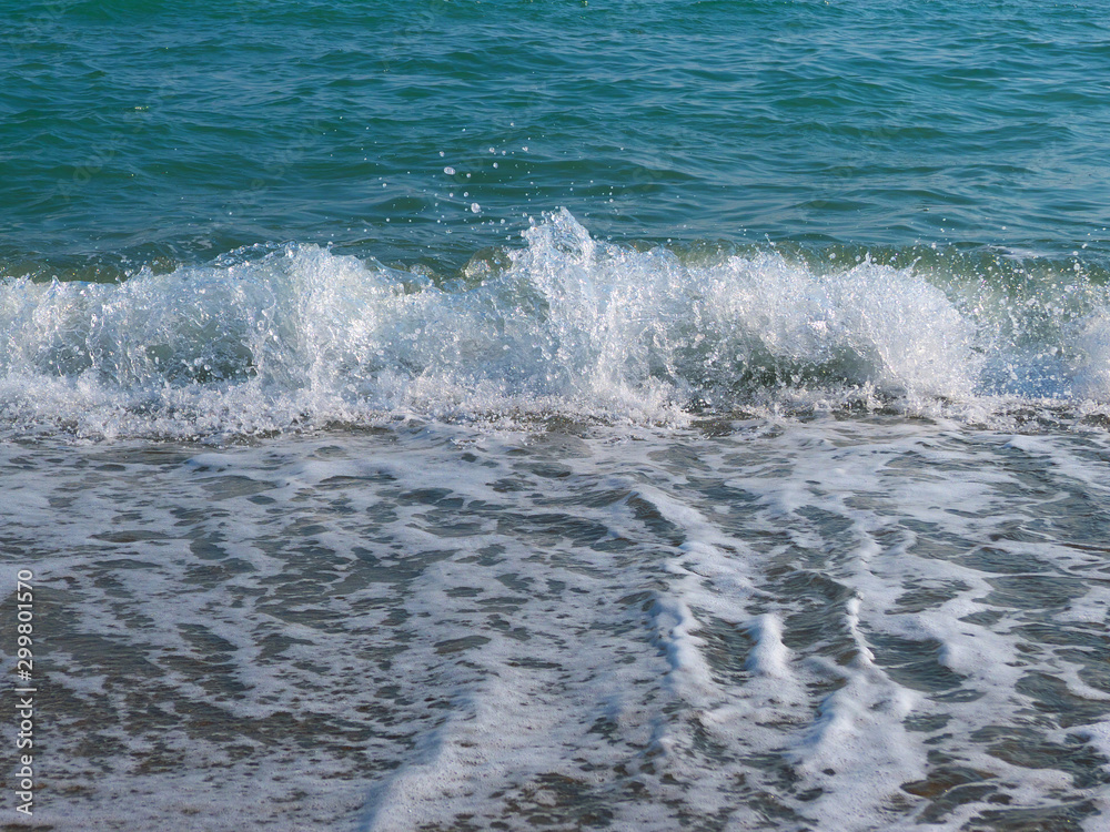 Closeup of Mediterranean Sea wave with surf and foam. High shutter speed fixation, front view, low angle 