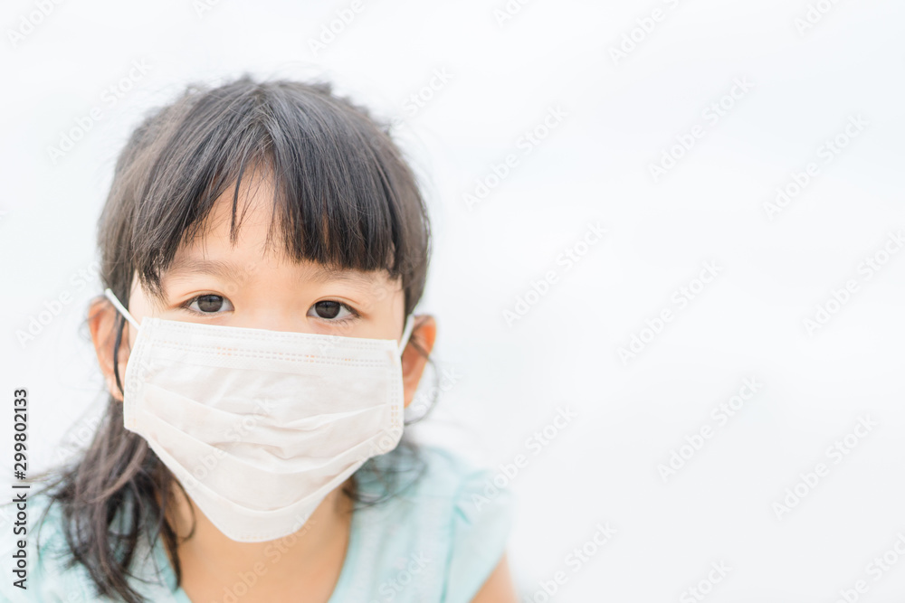 Little asian girl wearing a protective mask in school.bad weather, sickness, illness concept. Little asian girl wearing a protective mask in school.bad weather, sickness, illness concept.