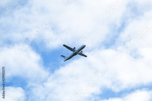 Airplane with propellers flying in blue sky. Commercial aircraft with propellers.