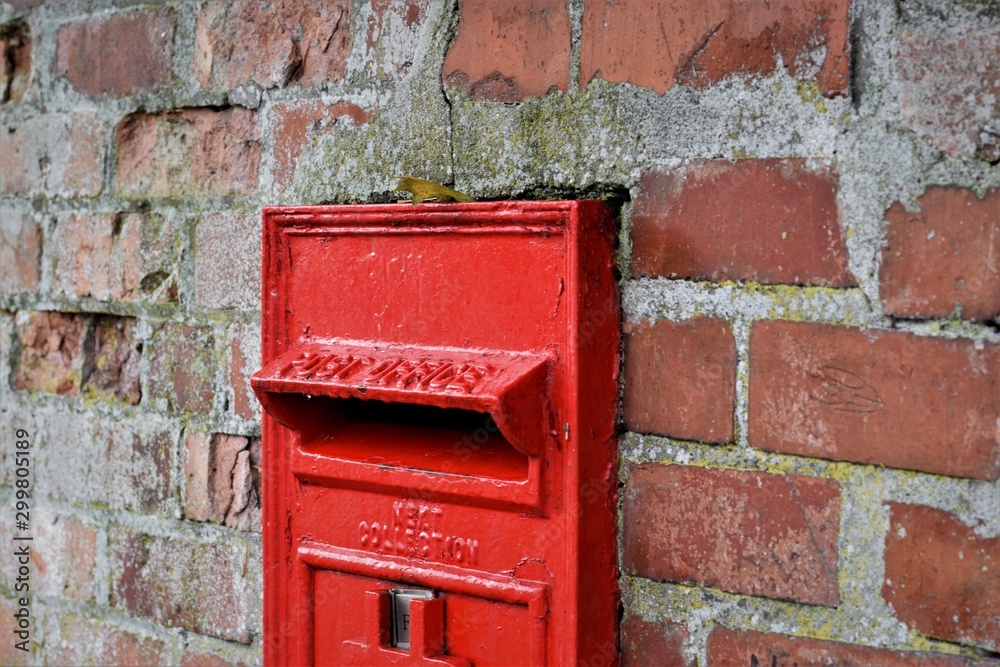 red mailbox on brick wall