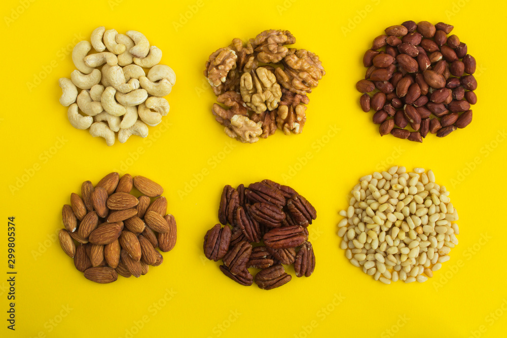 Set of different nuts on the yellow background. Top view. Closeup. Set of different nuts on the yellow background. Top view. Closeup.