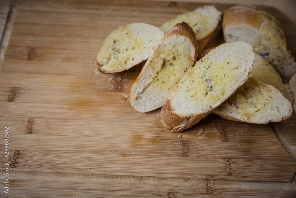 Tasty garlic bread, baguette on kitchen board