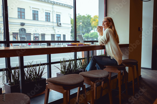 Smiling student in a coffee shop looking away © Viacheslav Yakobchuk