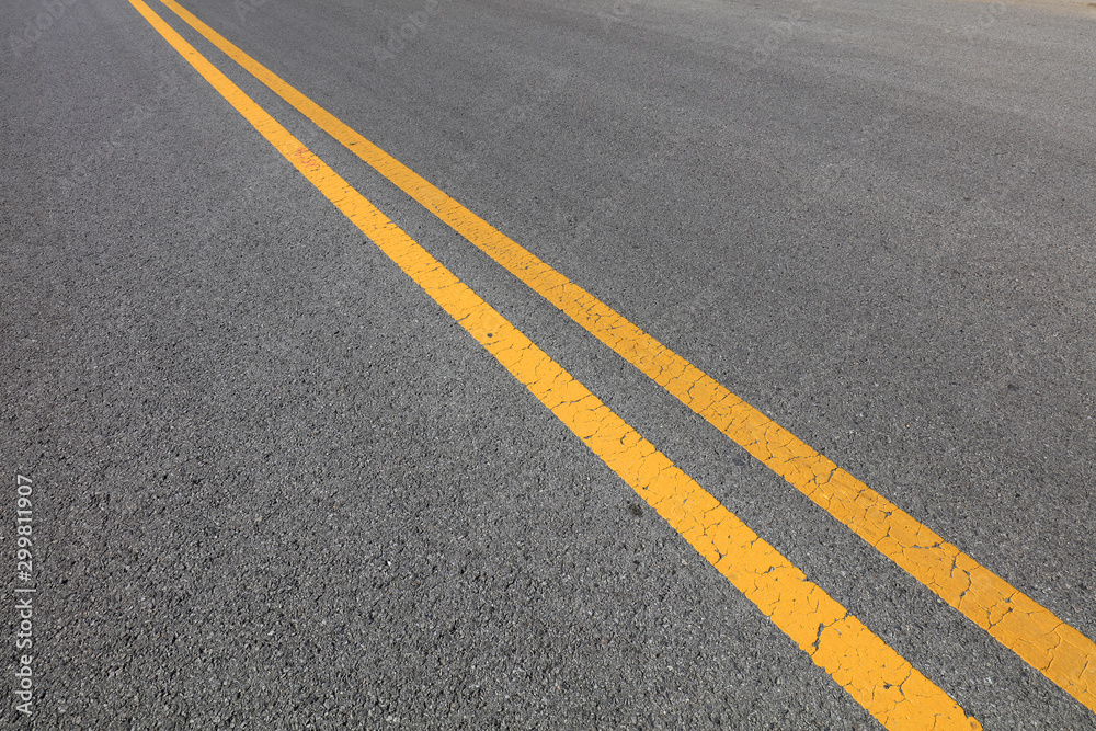 Yellow double solid line on the asphalt road