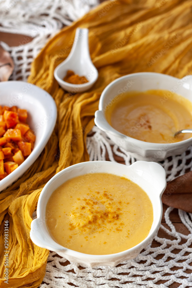 Pumpkin cream spiced with curry in a white bowl with roasted pumpkin and bread. Close Up Pumpkin cream spiced with curry in a white bowl with roasted pumpkin and bread. Close Up