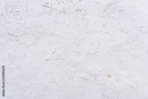 cracked and weathered white paint and plaster on wall background