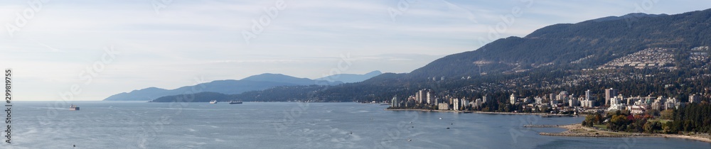 West Vancouver, British Columbia, Canada. Aerial Panoramic View of a modern cityscape on the Pacific Ocean Coast during an Autumn sunny and cloudy evening.