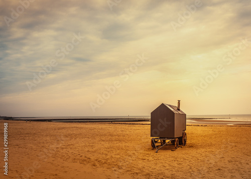 Wooden replica bathing machine with large cart wheels on a tranquil Margate beach in winter. photo