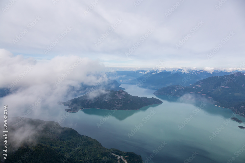 Aerial Landscape View of the Howe Sound during a cloudy summer morning. Taken North of Vancouver, British Columbia, Canada. Aerial Landscape View of the Howe Sound during a cloudy summer morning. Taken North of Vancouver, British Columbia, Canada.