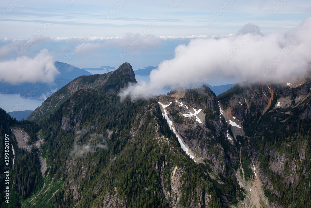 Aerial Landscape View of the Howe Sound Mountains during a cloudy summer morning. Taken North of Vancouver, British Columbia, Canada.