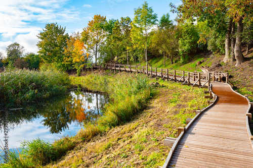 Wooden footpath along a small river. Beautiful natural landscape. photo