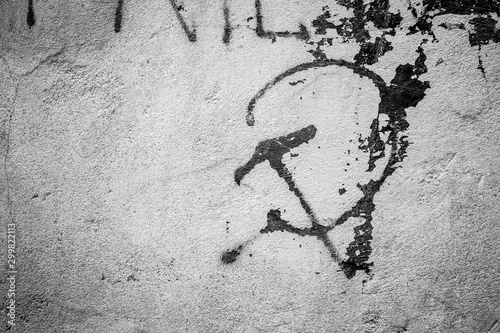 Communistic symbol: Grungy hammer and sickle graffiti on and old wall photo