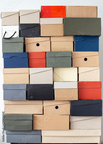 Quadro su tela Stack of unevenly folded shoe boxes against a white wall