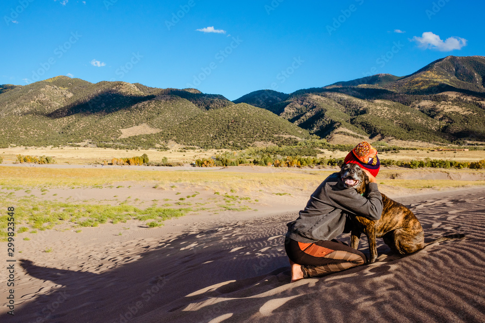 woman with dog hiking in the mountains and sand dunes