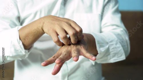 A man scratching his hand Because of itching