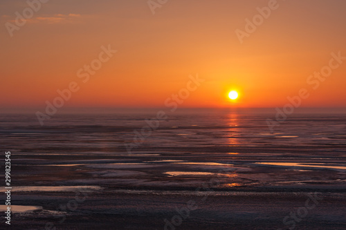 Fiery sunset in winter over frozen sea