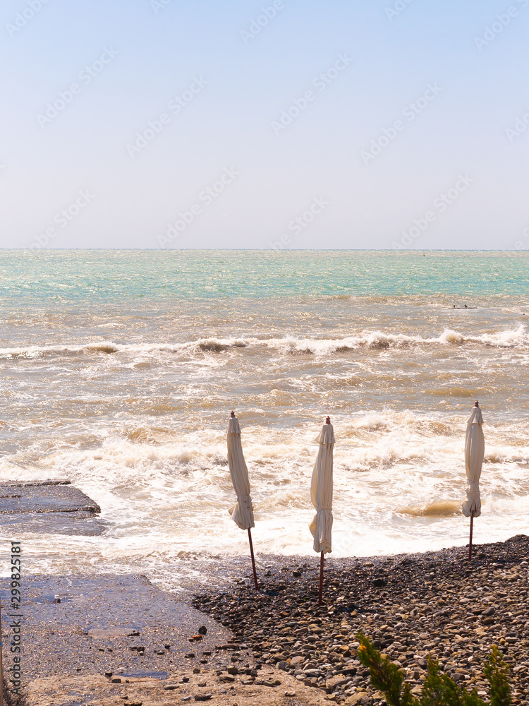 Beach umbrellas are closed. Stormy sea. Swimming is prohibited. Beach umbrellas are closed. Stormy sea. Swimming is prohibited.