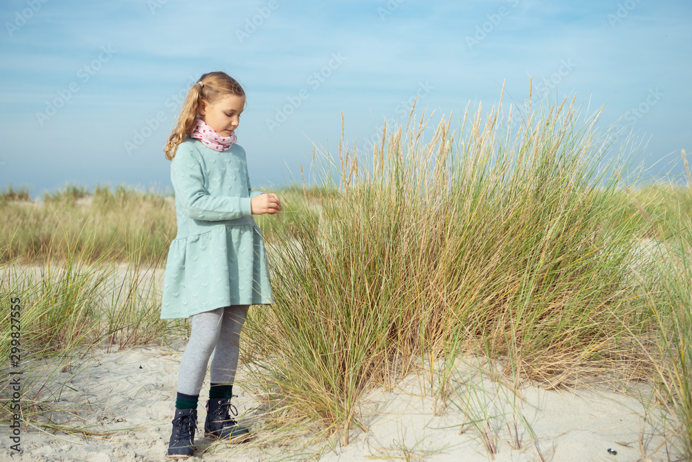 Portrait of pretty cheerful little girl in dress at sunny day on beach Portrait of pretty cheerful little girl in dress at sunny day on beach