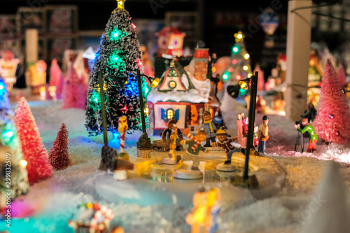 christmas time, miniature of houses and people, winter and snow at night, xmas houses decorated with lights  © tselykh