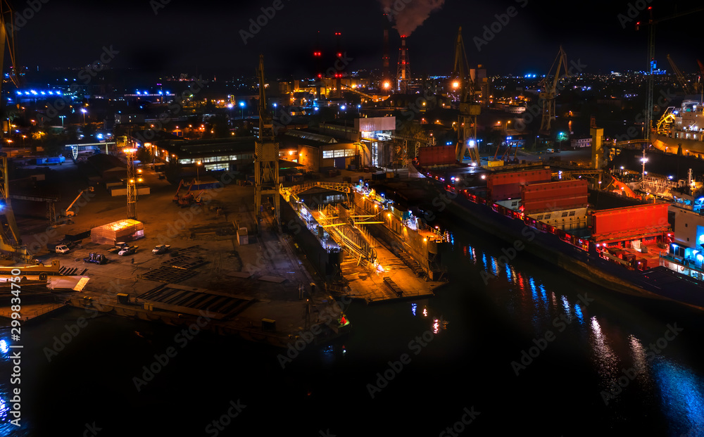 Night panorama Gdansk shipyard with submarine in to dry dock. Polish landscape, drone footage, night time.