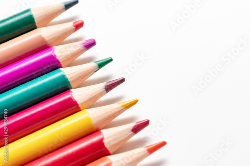 A set, assortment of colorful wooden pencils of different colors laying in row on white background with copy space