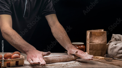 Baker is cooking bread. A man rolls out the dough © Артур Ничипоренко
