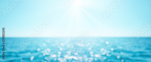 Beautiful Blur defocused blue sea background with sun rays and bokeh. Landscape of tropical summer. Summer vacation concept