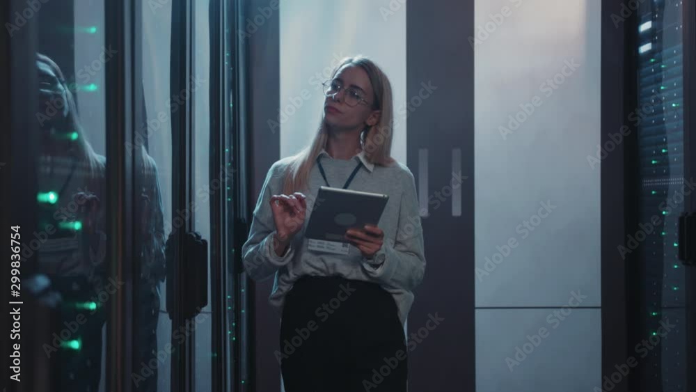 Young woman server engineer using tablet running diagnostics test with super computers server rack cabinets working in huge data center. Information and technology. Young woman server engineer using tablet running diagnostics test with super computers server rack cabinets working in huge data center. Information and technology.