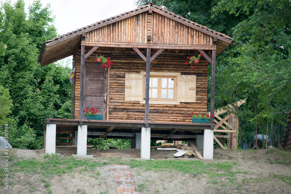 old wooden house in the forest on the riverbank