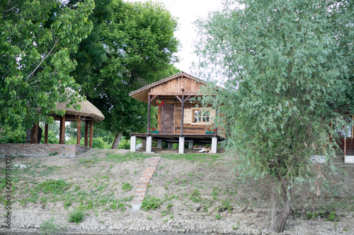 old wooden house in the forest on the riverbank