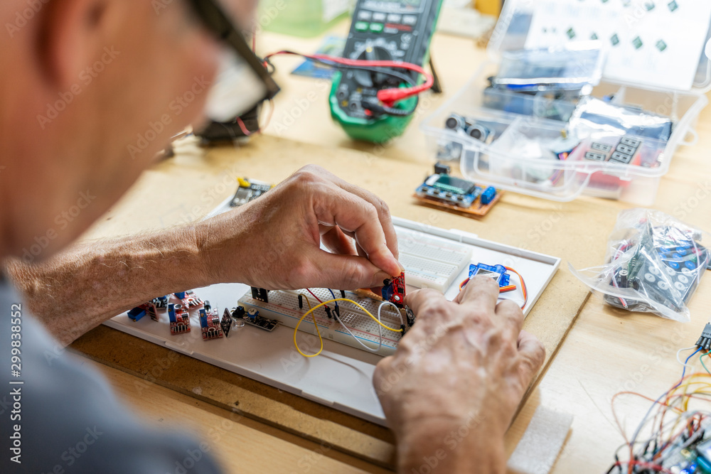 Barcelona, Spain. Senior man working with electronic circuits.