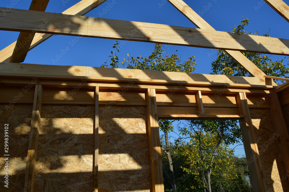 Construction of a wooden frame building. Small garden house with trees outside the window. Construction of a wooden frame building. Small garden house with trees outside the window.