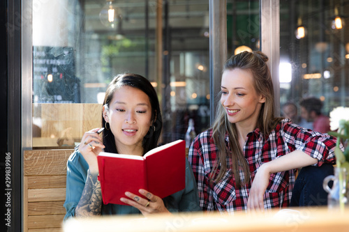 Two women with book in a cafe photo