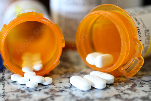 Photos Precription bottles of pain pills on a granite countertop.