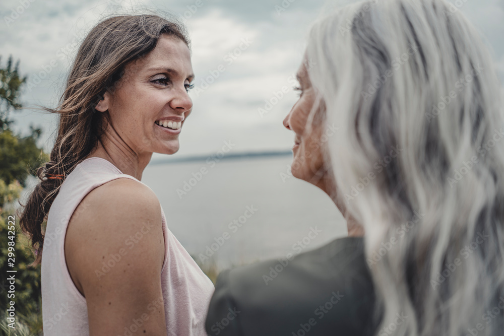 Mother and daughter talking on the beach Mother and daughter talking on the beach