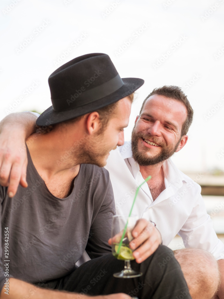 Young man at a party talking to a friend Young man at a party talking to a friend