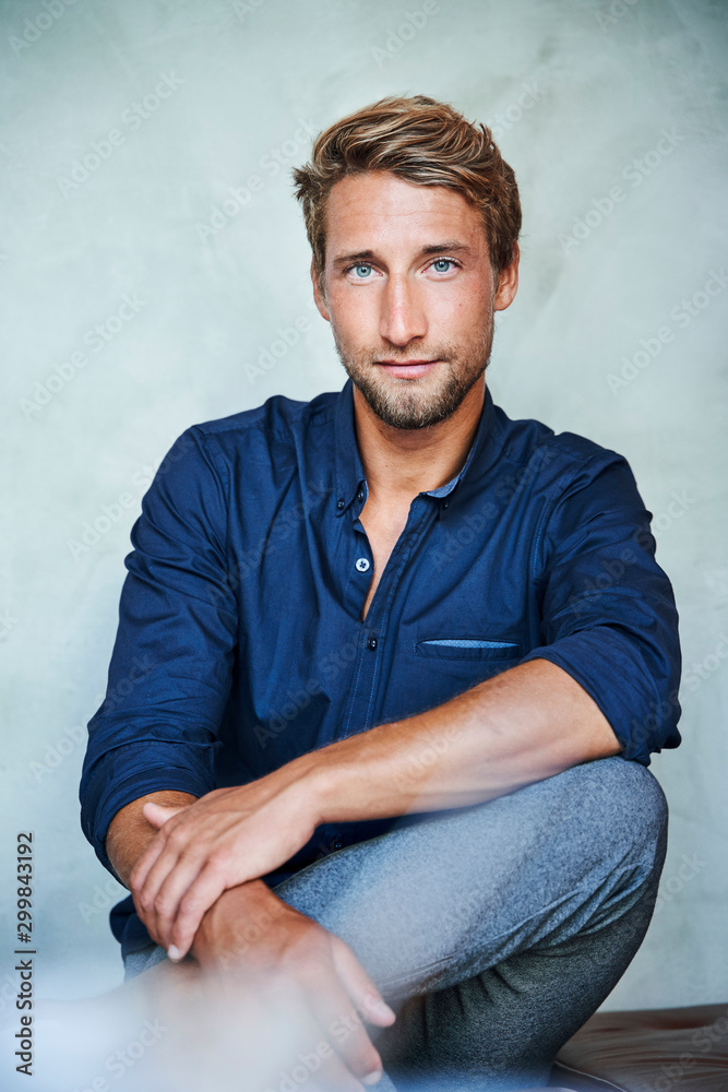 Portrait of confident young man sitting down Portrait of confident young man sitting down