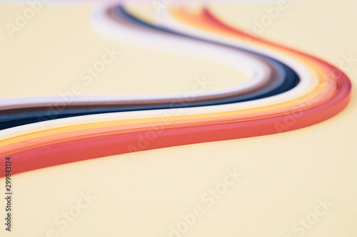 Close-up of quilling papers with swirl pattern on beige background