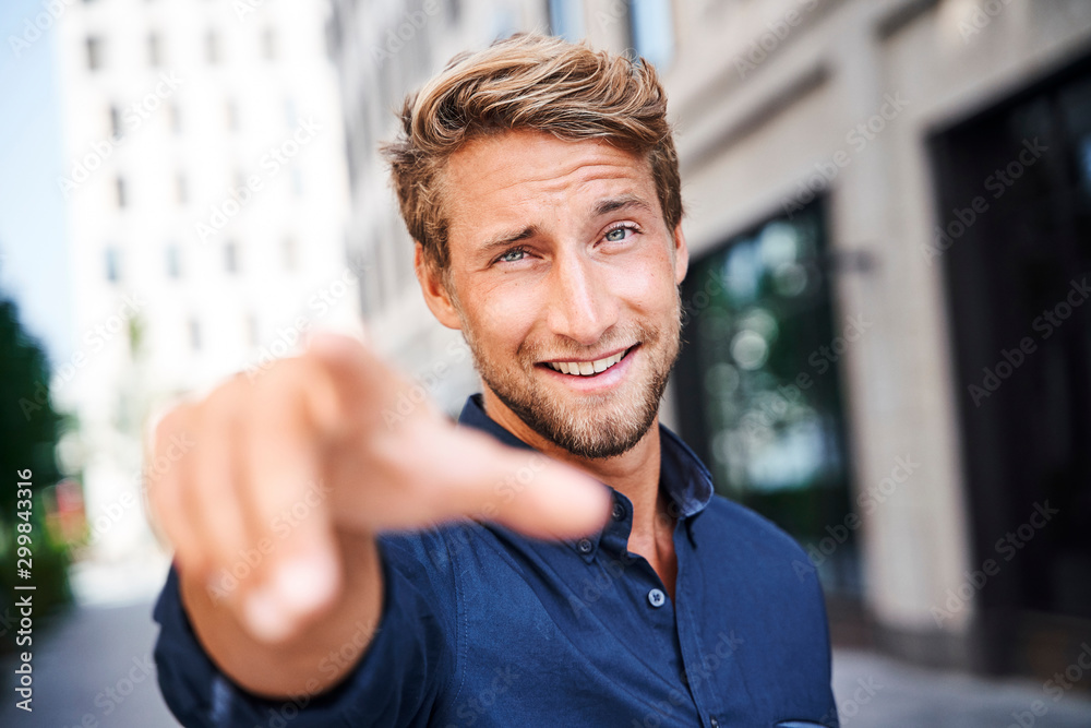 Portrait of confident young man in the city pointing his finger Portrait of confident young man in the city pointing his finger