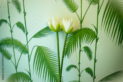 Tropical palm leaf wallpaper with white flowers. Feeling of Moominvalley. photo