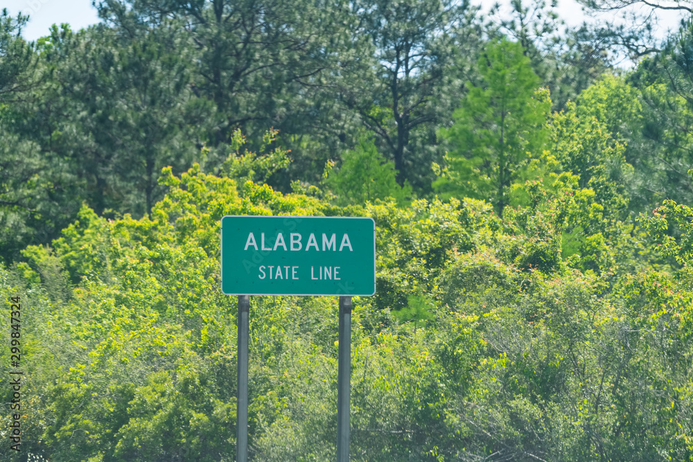 Highway road in Alabama and Mississippi border state line welcome sign and text on street on i10 in Grand Bay, AL