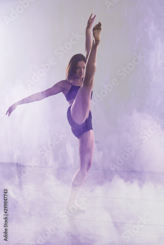 Fototapeta Naklejka Na Ścianę i Meble -  Young modern dancer dancing in the studio. Sport, dancing and urban culture concept. Group of young dancers performing on the stage. Effective performance. beautiful dance. full of energe dancers.