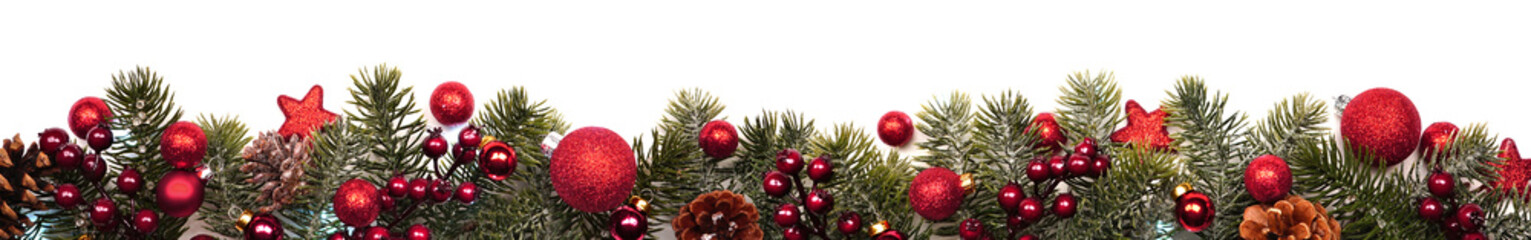 Long Christmas border banner of red ornaments and branches isolated on a white background